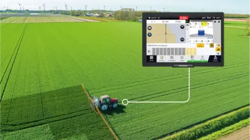 ISOBUS-controlled tractor spraying field with GPS guidance system.